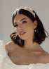 Woman wearing a pearl bridal headband with a neutral background