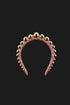 A dusty pink velvet headband adorned with a row of shiny gold metallic beads, shown against a solid black background.
