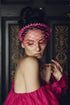 A woman wearing a pink magenta headband with a veiled design for spring racing photoshoot